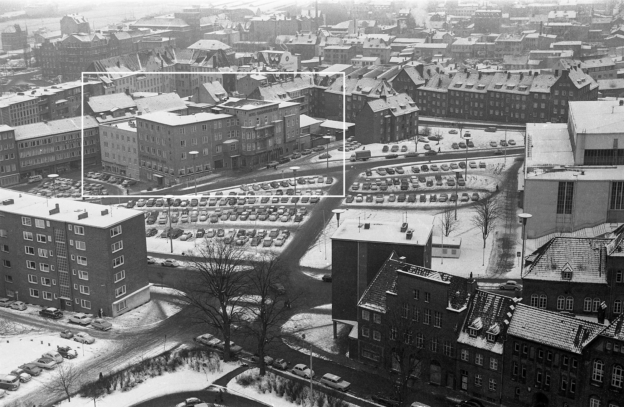 im Winter. Blick vom Rathausturm über die Waisenhofstraße (vorn rechts) und den Kleinen Kuhberg (vorn) zum Parkplatz vor der Ostseehalle (Bildmitte). Im Hintergrund links das Hotel Flensburger Hof am Großen Kuhberg 9-13 und rechts der Ziegelteich.